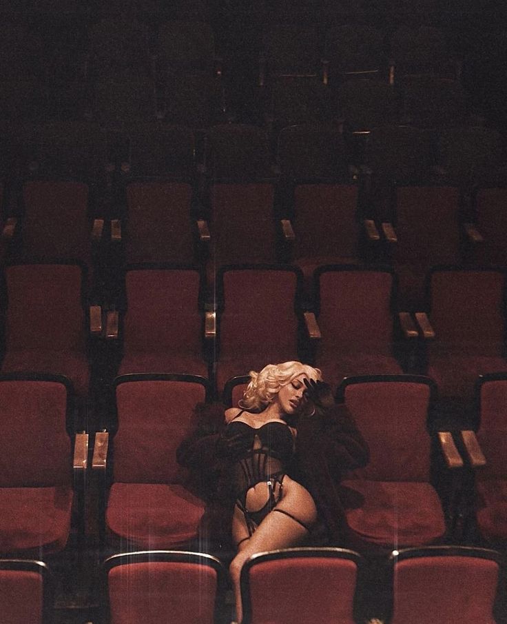A figure in an empty red theatre
